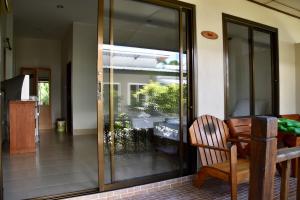 una puerta corredera de cristal en una casa con una silla en Magic Resort, en Lamai