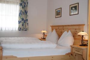 a bedroom with a bed with white sheets and pillows at Bauerndörfl Hüttschlag in Hüttschlag