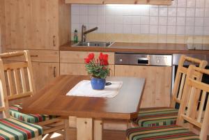 a kitchen with a table with a vase of flowers on it at Bauerndörfl Hüttschlag in Hüttschlag