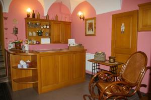 a kitchen with wooden cabinets and pink walls at Penzion Koudela in Česká Kamenice