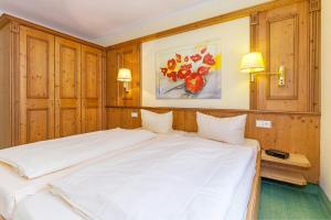un grande letto bianco in una stanza con pareti in legno di Sonnhof Reit im Winkl a Reit im Winkl