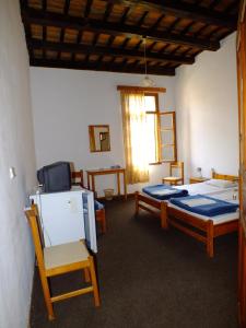 a bedroom with two beds and a chair and a window at Lito Rooms in Chania Town