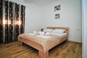 a bedroom with a bed with two red candles on it at Apartmani Bekonja in Tivat