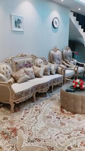 sala de estar con sofá, sillas y mesa en زائر الشمال للشقق الفندقية en Sakaka