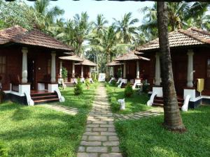 a walkway in front of a resort with palm trees at Rajadhani 5th Season in Varkala