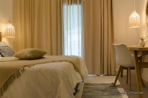 a bedroom with a bed and a table and a chair at Alfa Hotel in Parga