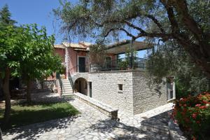 a brick house with a balcony on top of it at Sivota Muses in Syvota