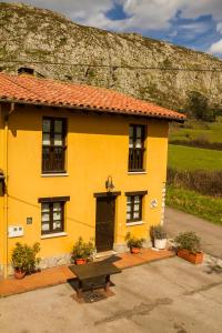 una casa amarilla con un banco delante en Casa Rural Peña Careses, en Careses