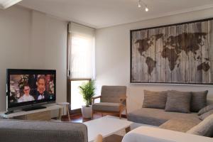 a living room with a couch and a flat screen tv at PRECIOSO APARTAMENTO EN EL CENTRO - MAX. 6 PERSONAS in Ezcaray