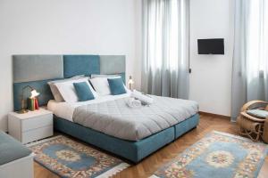 um quarto com uma cama grande e uma cabeceira azul em B&B Villa Romano em Treviso