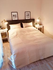 una camera da letto con un grande letto bianco con due lampade di Ferienwohnung Ananda auf Fehmarn a Fehmarn