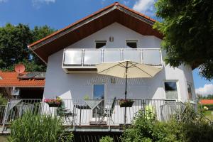 プラインフェルトにあるFerienhaus "Kleine Auszeit"の白い家(バルコニー、傘付)
