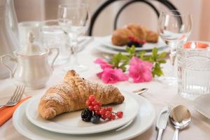 una mesa blanca con platos de comida. en B&B Villa Romano, en Treviso