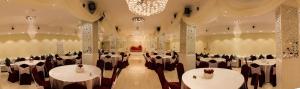 a banquet hall with tables and chairs and a chandelier at Hotel Mellasse in Tissemsilt