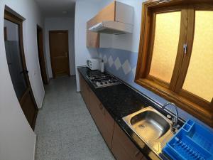 a small kitchen with a sink and a stove at Pozo Izquierdo Homelidays in Pozo Izquierdo