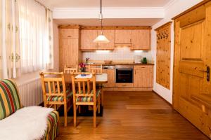 a kitchen with wooden cabinets and a table and chairs at Bauerndörfl Hüttschlag in Hüttschlag