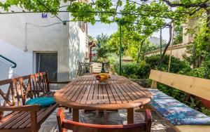 a wooden table and chairs on a patio at Three-Bedroom Apartment Meden in Pomer