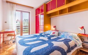 a bedroom with a bed and a desk and a window at Three-Bedroom Apartment Meden in Pomer