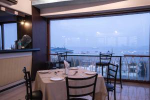 a table in a restaurant with a view of a harbor at Hotel Godwin - Colaba in Mumbai