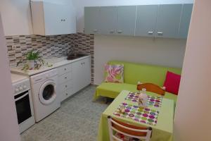 a small kitchen with a table and a washing machine at Green Garden Studios in Koskinou