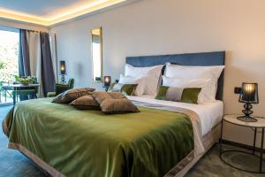 een slaapkamer met een groot bed en een groene deken bij Boutique Hotel Acacia in Lovran