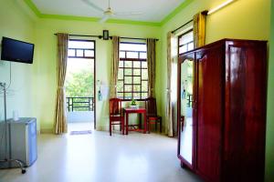 a living room with a room with a table and chairs at Cat Tien Guesthouse in Mui Ne