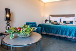 a room with two beds and a table with a bowl of vegetables at Boutique Hotel Acacia in Lovran