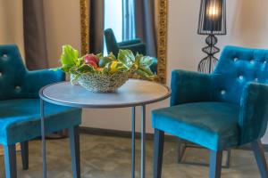 a table with blue chairs and a vase of flowers at Boutique Hotel Acacia in Lovran
