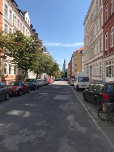 an empty street with cars parked on the side of the road at Nord Apartment in Kiel