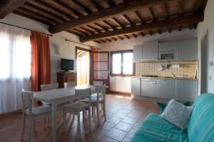- une cuisine et une salle à manger avec une table et des chaises dans l'établissement Serra Destri, à Riparbella