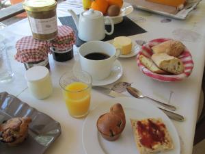 a table topped with plates of breakfast foods and orange juice at Maison d'Hôtes Le Moulin Pointu in Sainte-Nathalène