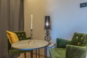 a table with a candle and green chairs at Boutique Hotel Acacia in Lovran