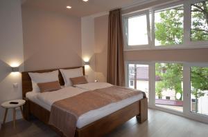 a bedroom with a large bed and large windows at Villa Aba apartments in Sarajevo