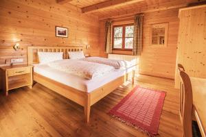a bedroom with a bed in a wooden cabin at Bauerndörfl Hüttschlag in Hüttschlag