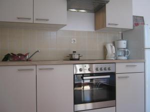 a kitchen with white cabinets and a stove top oven at Apartments Blanka in Zadar