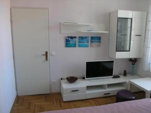um quarto branco com uma televisão num armário branco em Hvar apartment 4 em Hvar