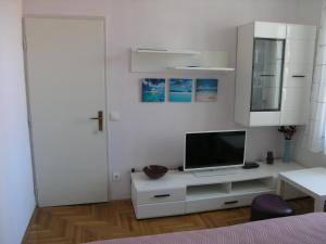 ein weißes Schlafzimmer mit einem TV auf einem weißen Schrank in der Unterkunft Hvar apartment 4 in Hvar