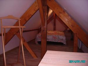 a room with a ladder and a bed in a attic at La Grimodière Gîte in Ranville +14 photos