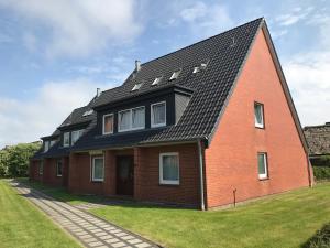 ein rotes Backsteinhaus mit schwarzem Dach in der Unterkunft Apartment Yoursylt One in Westerland