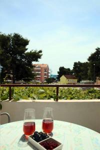 a table with two glasses of wine and a tray of food at Apartments & Rooms Samohod in Vodice