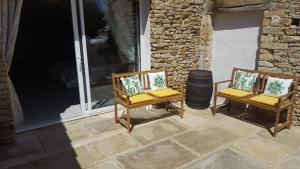 two chairs sitting on a patio with a barrel at Le Champêtre in Bazoges-en-Pareds