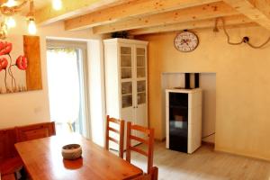 a kitchen with a table and a clock on the wall at LA MAGNOLIA Guests House in Dervio