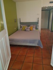 a bed with pillows on it in a room at Résidence Anse des Rochers in Saint-François