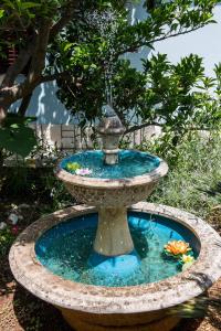 a bird bath with a fountain in a garden at Star in Mali Lošinj