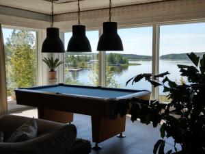 a pool table in a living room with a view of a lake at Villa Seaview Guesthouse & Spa in Teijo