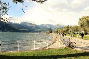 a bike parked on a sidewalk next to a body of water at LA MAGNOLIA Guests House in Dervio
