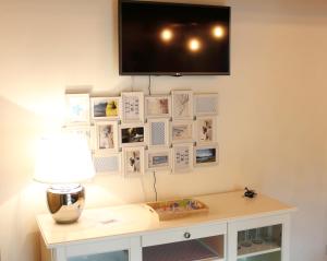 una camera con tavolo e TV a parete di LA MAGNOLIA Guests House a Dervio