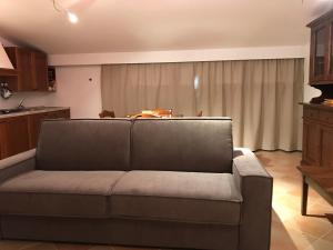 a living room with a couch in front of a window at La Poderina Appartamenti in Castelnuovo dellʼAbate