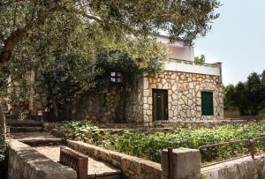 a stone building with a door and a tree at Holiday Home Laurea in Supetar
