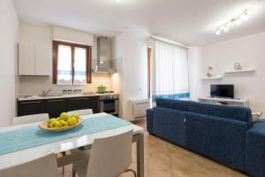 salon z niebieską kanapą i stołem z misą owoców w obiekcie La Casa di Noemi w mieście Alghero